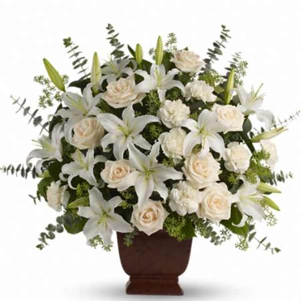 White lilies and cream roses arranged in a brown vase