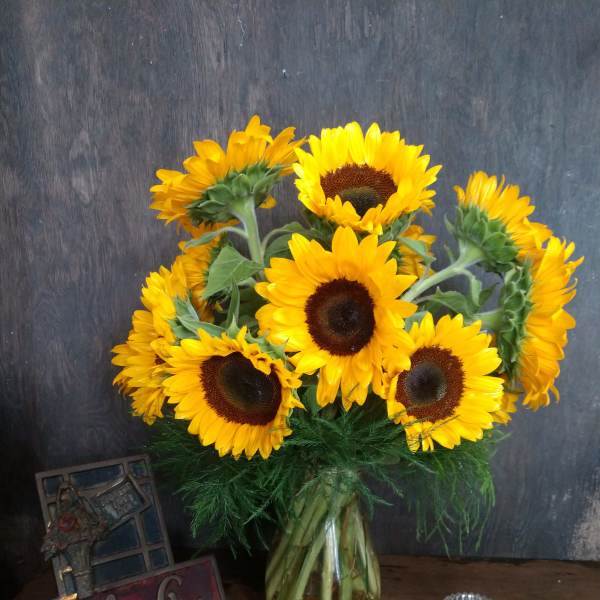 Bouquet of yellow sunflowers in a glass vase