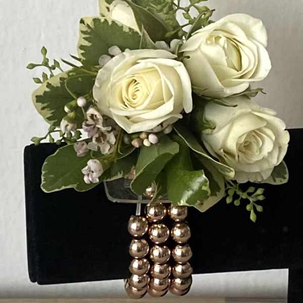 White rose bouquet with green foliage and a beaded handle