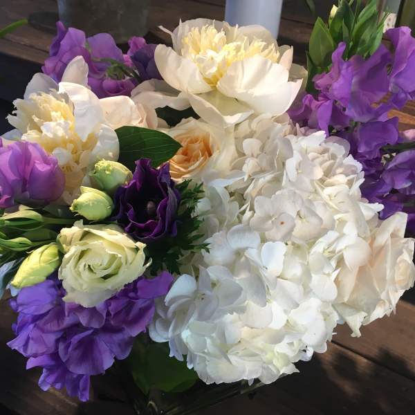Bouquet of white hydrangeas, purple blooms, and cream roses