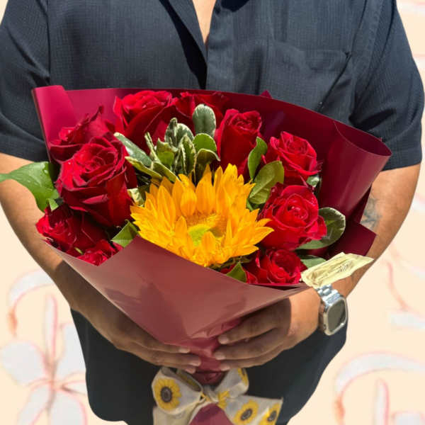 Bouquet of red roses and a yellow sunflower wrapped in burgundy paper