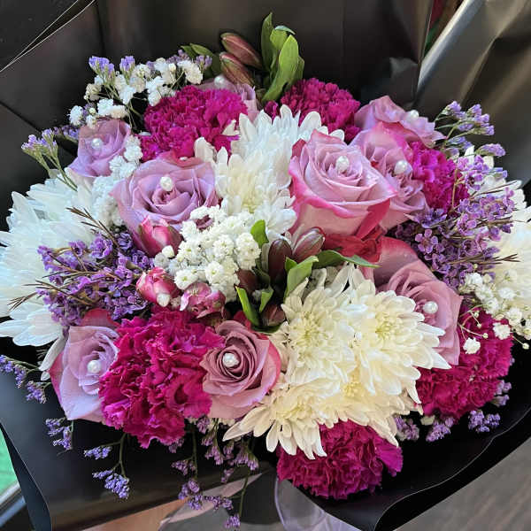 Bouquet of pink roses, white chrysanthemums, and purple filler flowers