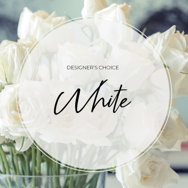 White roses in a clear glass vase with a "Designer’s Choice White" label