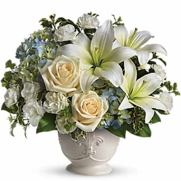 White lilies and cream roses arranged in a decorative vase