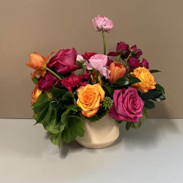 Mixed bouquet of roses and tulips in a cream vase