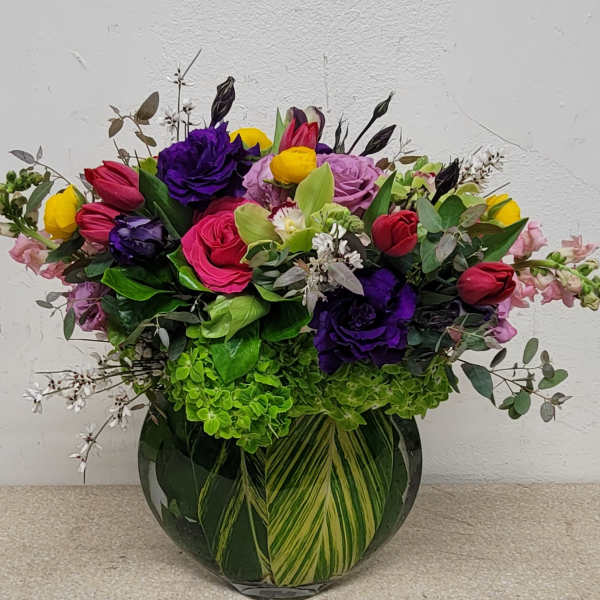 Mixed bouquet of colorful roses and tulips in a glass vase