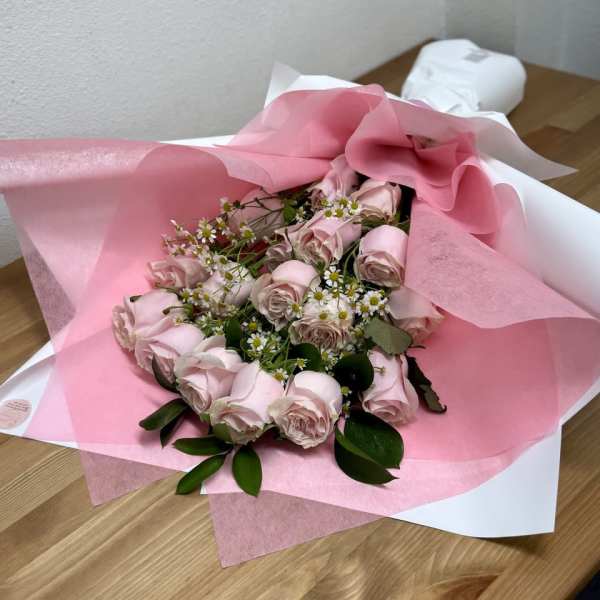 Pink rose bouquet wrapped in pink and white paper