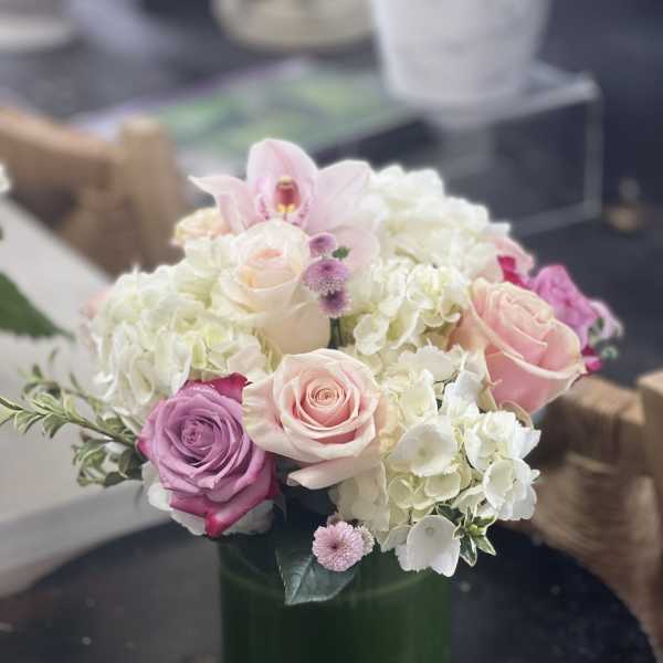 Pink and white roses with hydrangeas in a glass vase