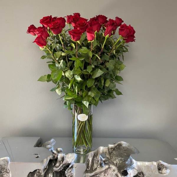 Tall bouquet of red roses in a clear glass vase