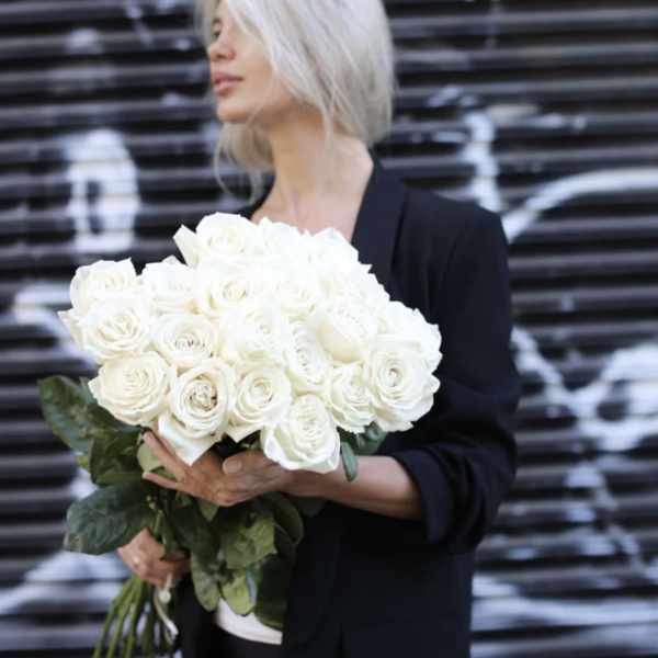 Woman holding a large bouquet of white roses
