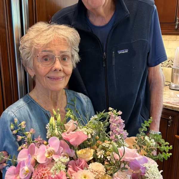 Woman holding a large pastel bouquet with pink and lavender flowers