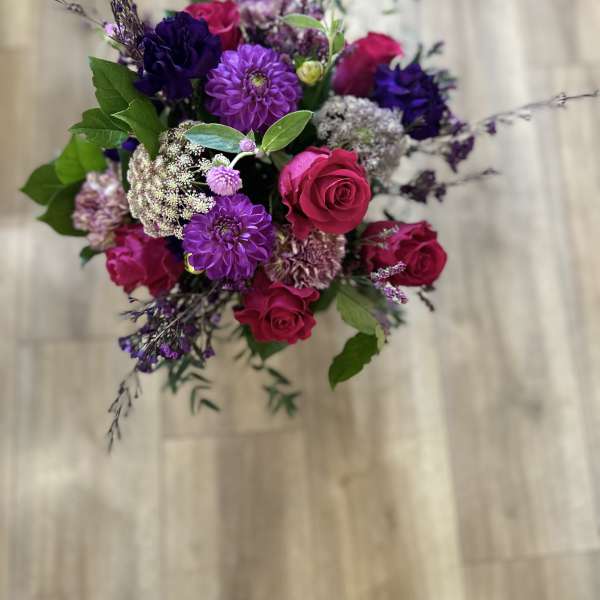 Bouquet of pink roses and purple flowers with greenery