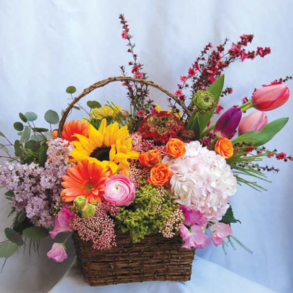 Colorful mixed flower basket with sunflowers, roses, tulips, and hydrangea