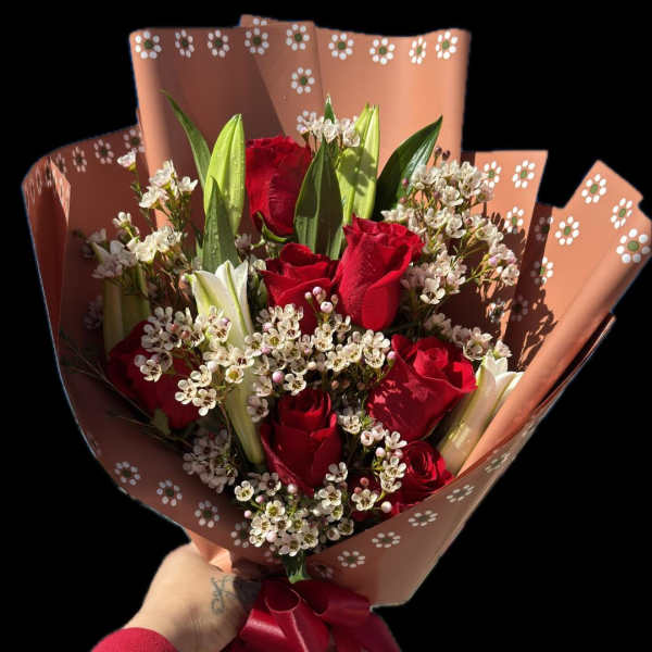 Bouquet of red roses and white lilies wrapped in pink paper