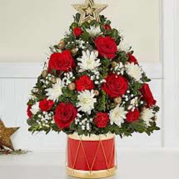 Christmas tree-shaped floral arrangement in a red drum container