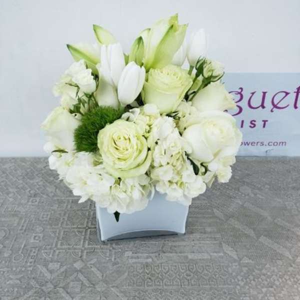 White floral arrangement in a square white vase