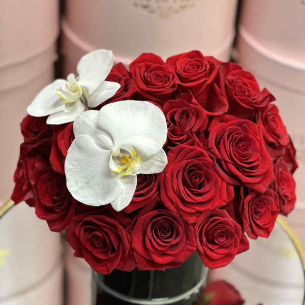 Red rose bouquet with two white orchids in a black vase