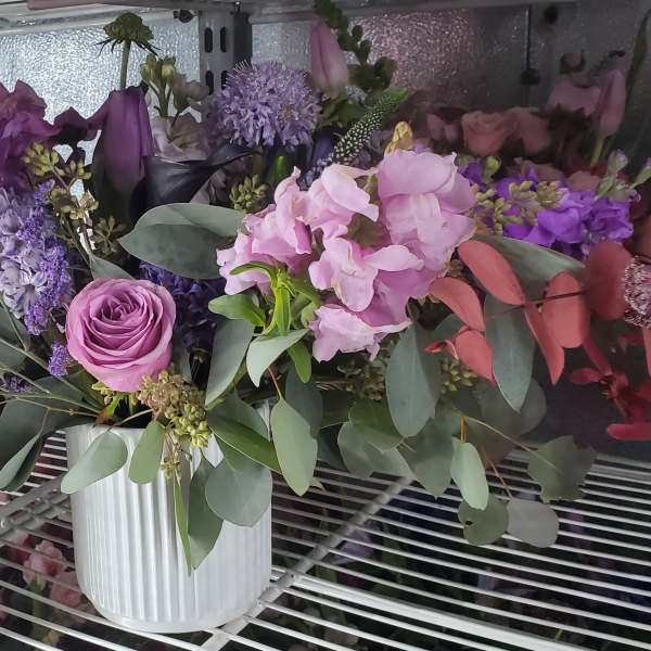 Purple and pink mixed bouquet in a white vase