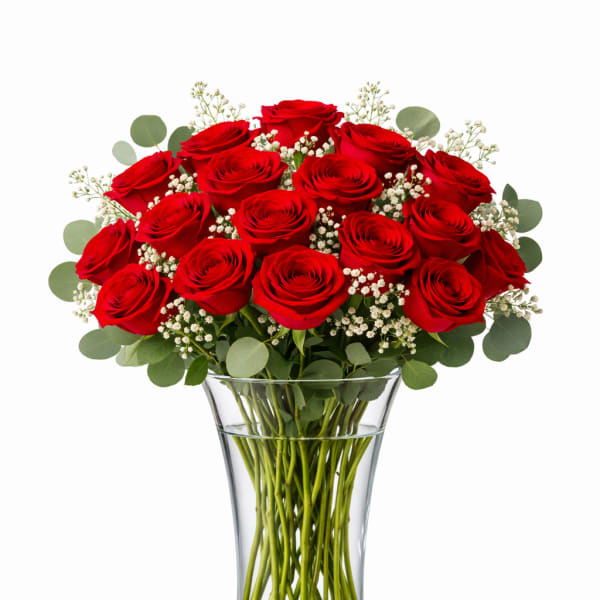 Red roses arranged in a clear glass vase with baby's breath