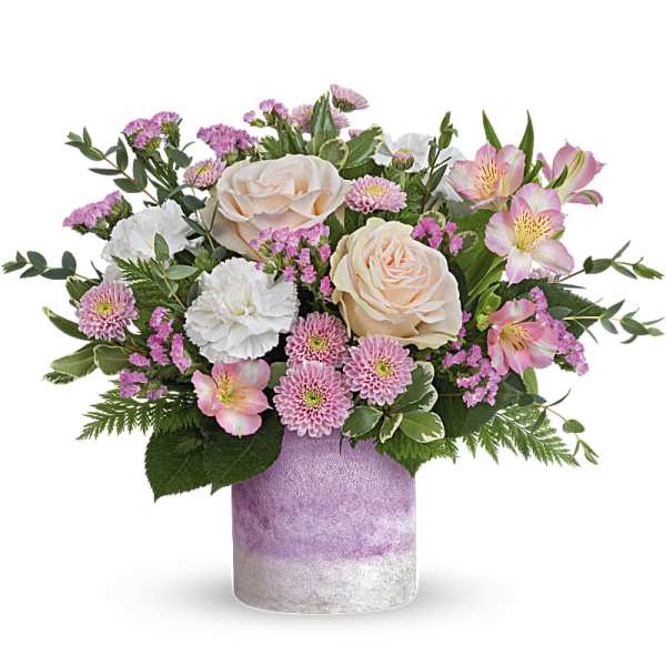 Pink and white mixed flower arrangement in a lavender vase