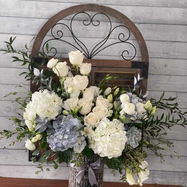 White and blush roses with hydrangeas in a glittery vase
