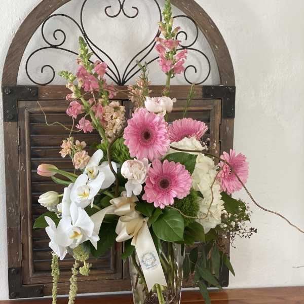 Pink and white mixed flower arrangement in a clear vase