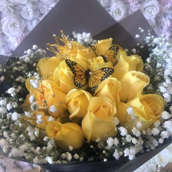 Yellow rose bouquet with baby’s breath, butterfly picks, and a small crown