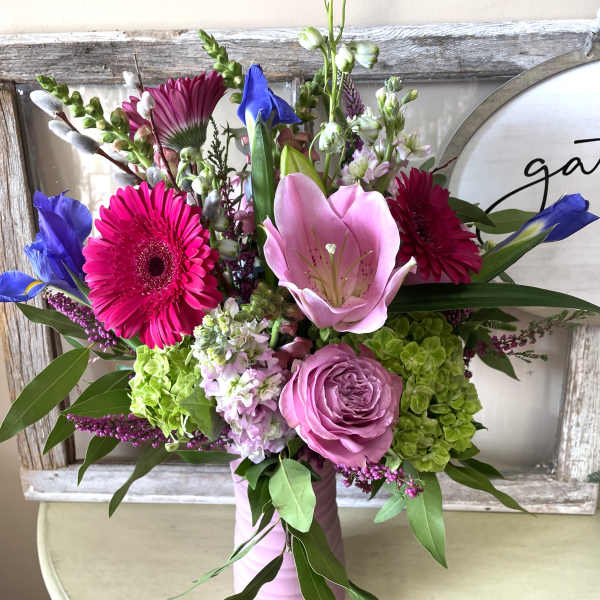 Mixed bouquet with pink and purple flowers in a pink vase