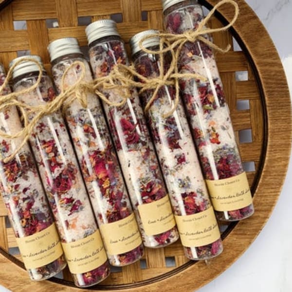 Five glass tubes filled with dried flower bath salts tied with twine