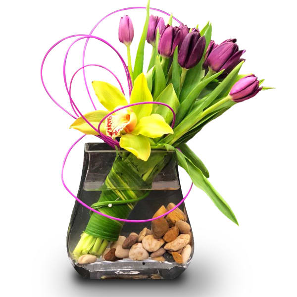 Purple tulips and a yellow orchid in a black glass vase