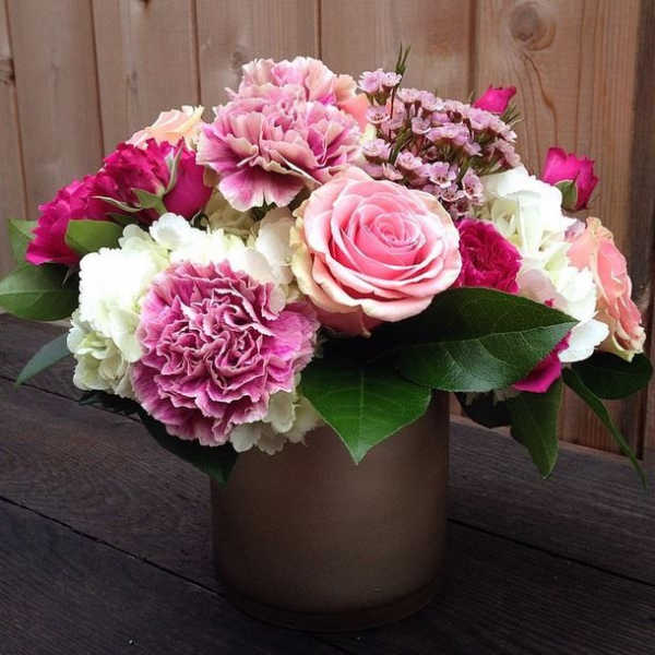 Pink and white flower arrangement in a brown vase