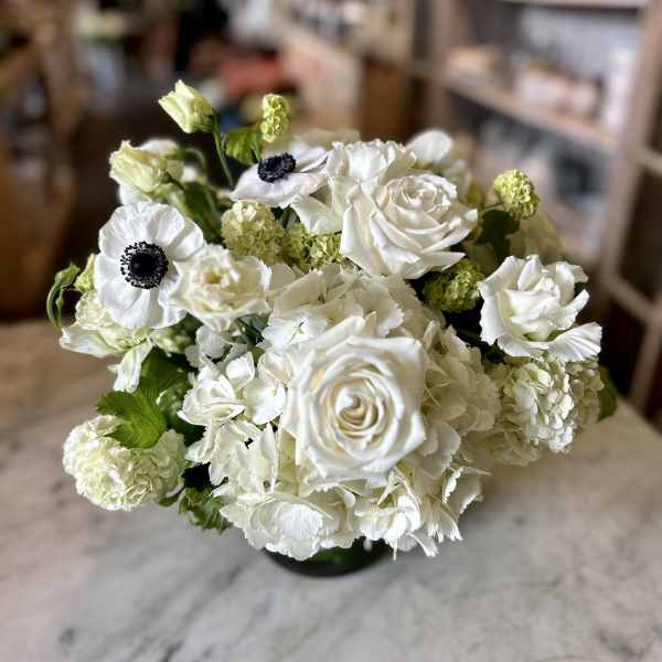 White roses and anemones in a compact bouquet