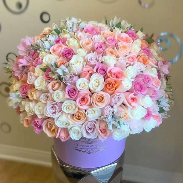 Large pastel rose arrangement in a lavender hat box container