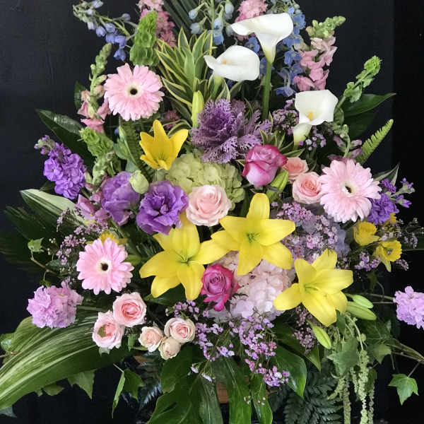 Large mixed floral arrangement with lilies, roses, calla lilies, and gerbera daisies