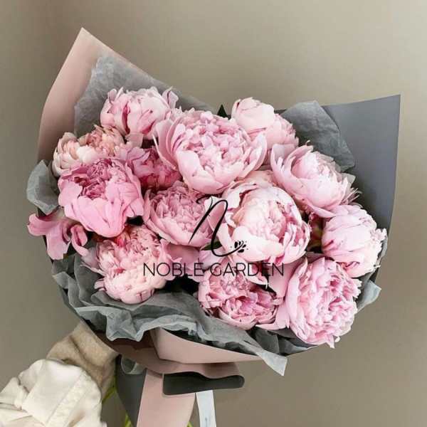 Bouquet of pale pink peonies wrapped in gray and blush paper