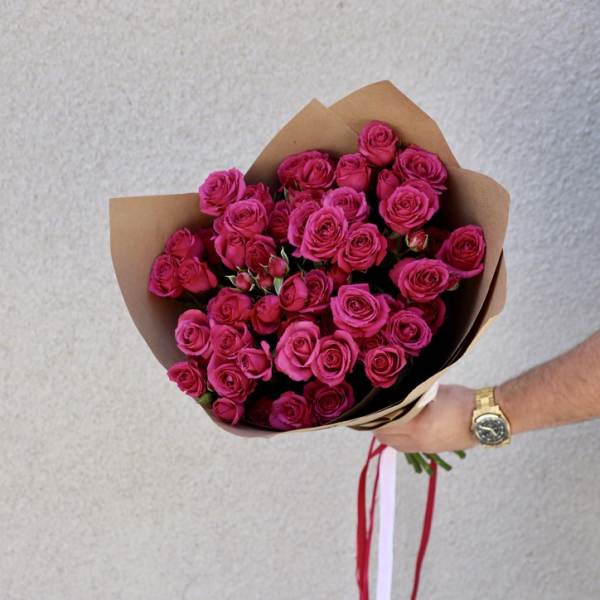 Bouquet of bright pink roses wrapped in brown paper