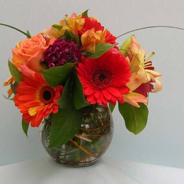 Mixed bouquet of gerbera daisies and roses in a glass vase