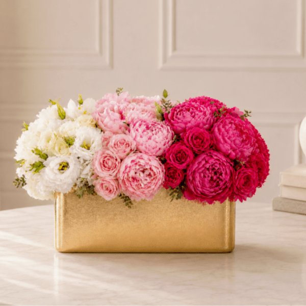 Pink and white flower arrangement in a gold rectangular box
