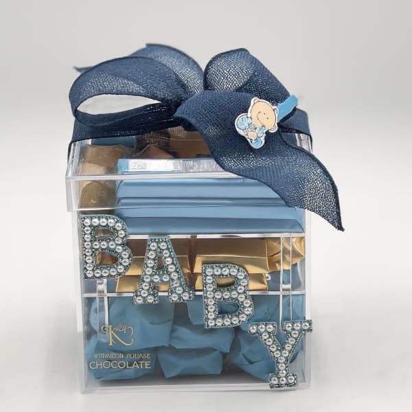 Clear gift box with blue ribbon and chocolate pieces labeled BABY