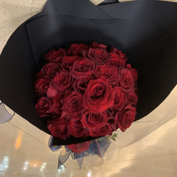 Bouquet of red roses wrapped in black paper