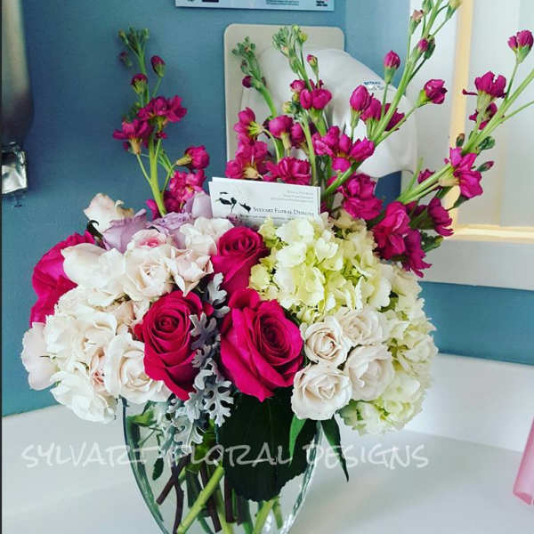 Bouquet of pink roses and white hydrangeas in a glass vase