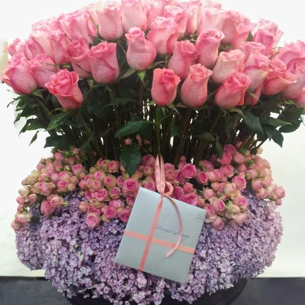 Large pink rose arrangement with a gift box and ribbon