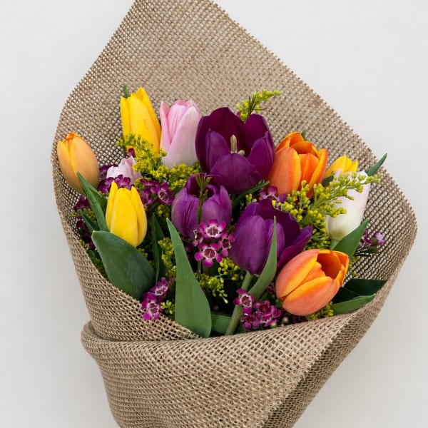 Bouquet of multicolored tulips wrapped in burlap