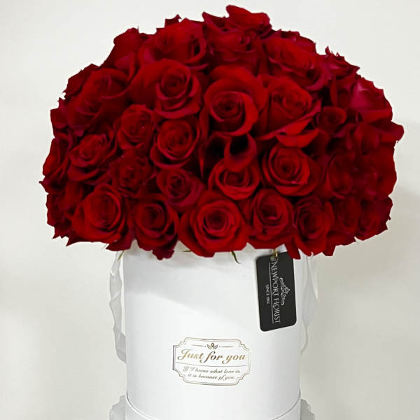 Red rose bouquet in a white hat box with ribbon