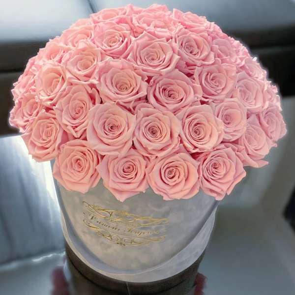 Round bouquet of pale pink roses in a gray hatbox