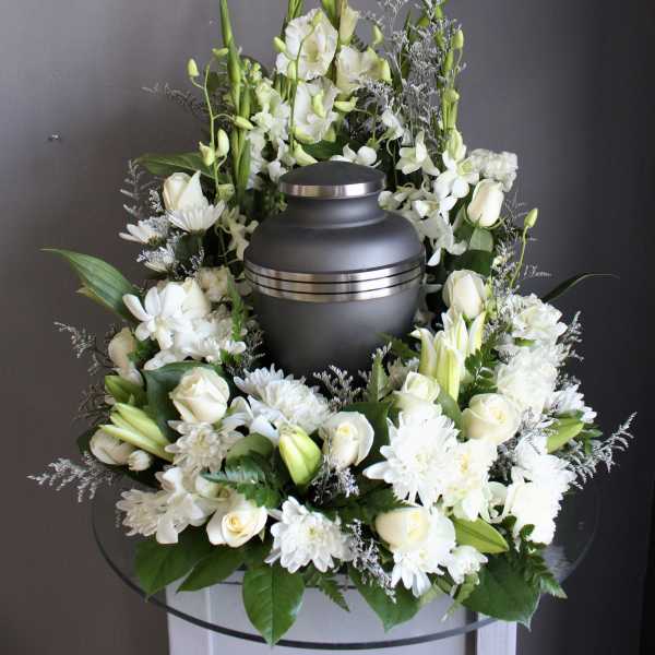 White floral funeral urn arrangement with roses, lilies, and chrysanthemums