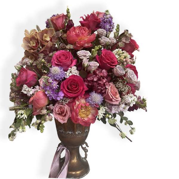 Mixed bouquet of pink and purple flowers in a bronze vase