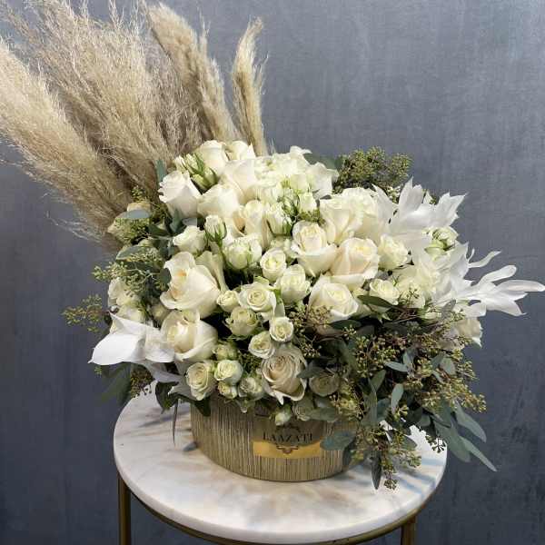 White rose arrangement in a round box with pampas grass