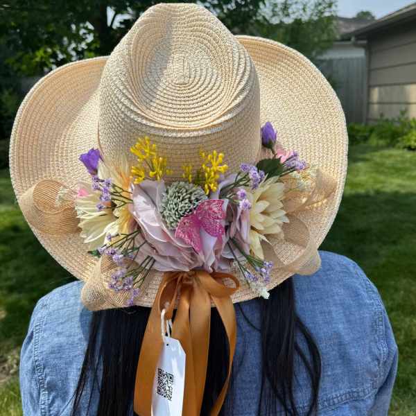 Straw hat decorated with pastel flowers and ribbon