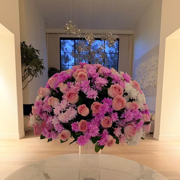 Large pink and white floral arrangement in a clear glass vase